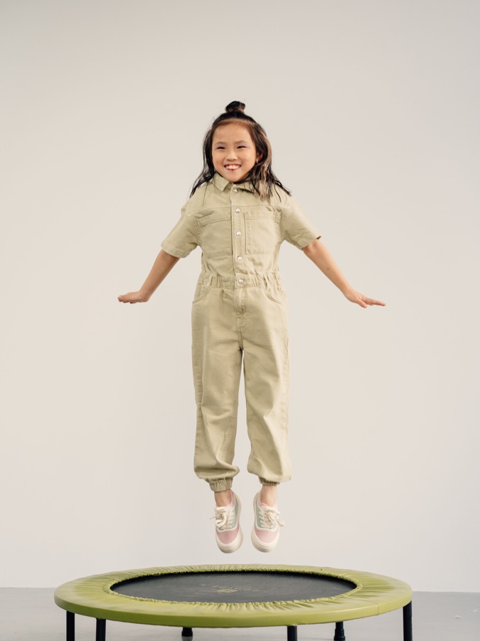 A child smiling while bouncing on an indoor trampoline